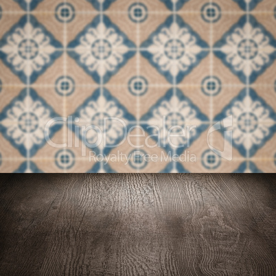 Wood table top and blur vintage ceramic tile pattern wall