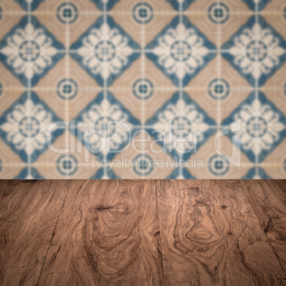 Wood table top and blur vintage ceramic tile pattern wall