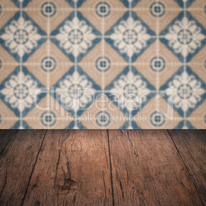 Wood table top and blur vintage ceramic tile pattern wall