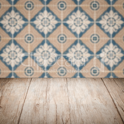 Wood table top and blur vintage ceramic tile pattern wall