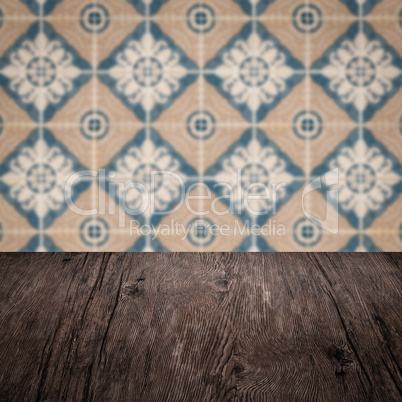 Wood table top and blur vintage ceramic tile pattern wall