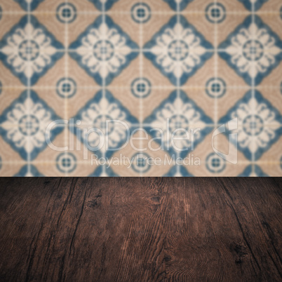 Wood table top and blur vintage ceramic tile pattern wall