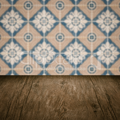 Wood table top and blur vintage ceramic tile pattern wall Wood table top and blur vintage ceramic tile pattern wall