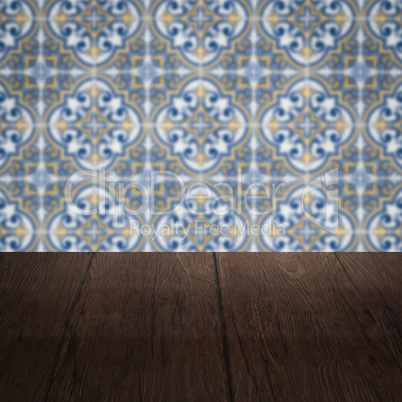 Wood table top and blur vintage ceramic tile pattern wall Wood table top and blur vintage ceramic tile pattern wall