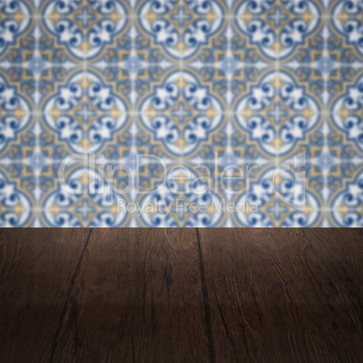 Wood table top and blur vintage ceramic tile pattern wall