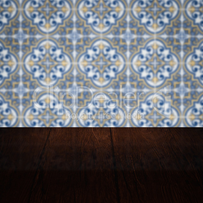 Wood table top and blur vintage ceramic tile pattern wall