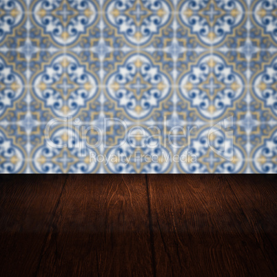 Wood table top and blur vintage ceramic tile pattern wall