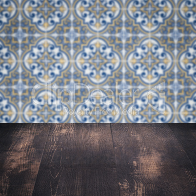 Wood table top and blur vintage ceramic tile pattern wall