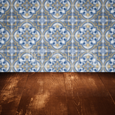 Wood table top and blur vintage ceramic tile pattern wall