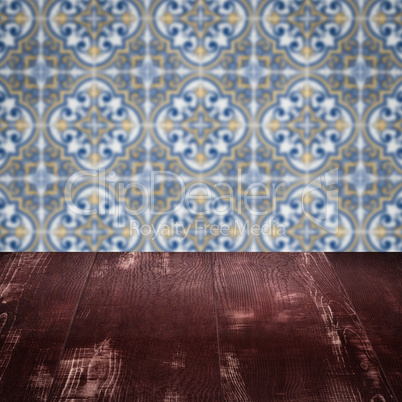 Wood table top and blur vintage ceramic tile pattern wall