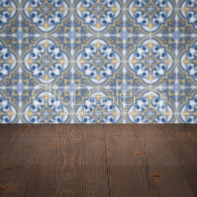 Wood table top and blur vintage ceramic tile pattern wall Wood table top and blur vintage ceramic tile pattern wall