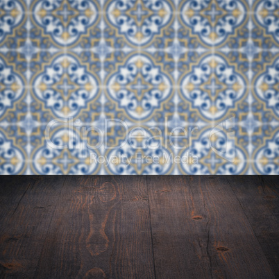 Wood table top and blur vintage ceramic tile pattern wall