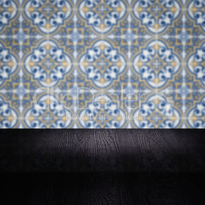 Wood table top and blur vintage ceramic tile pattern wall Wood table top and blur vintage ceramic tile pattern wall