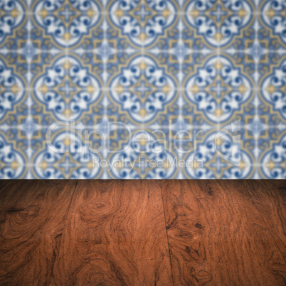 Wood table top and blur vintage ceramic tile pattern wall