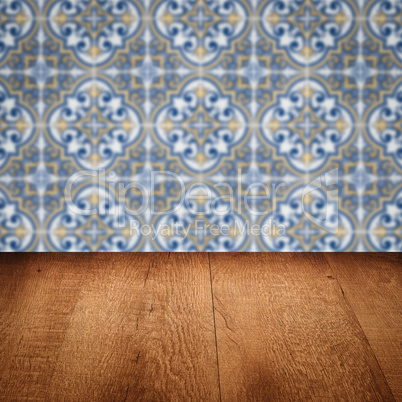 Wood table top and blur vintage ceramic tile pattern wall