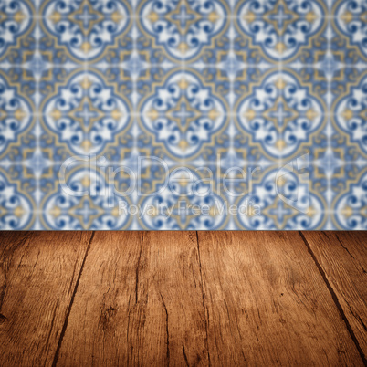 Wood table top and blur vintage ceramic tile pattern wall