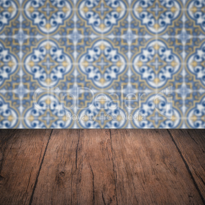 Wood table top and blur vintage ceramic tile pattern wall