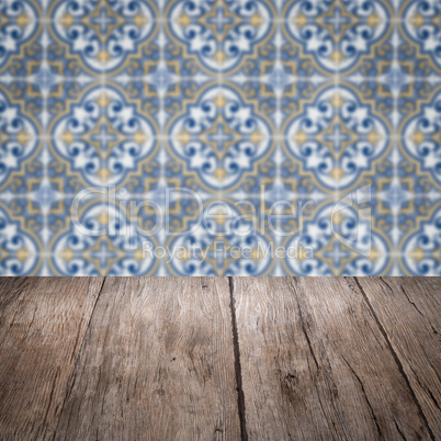 Wood table top and blur vintage ceramic tile pattern wall Wood table top and blur vintage ceramic tile pattern wall