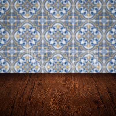 Wood table top and blur vintage ceramic tile pattern wall