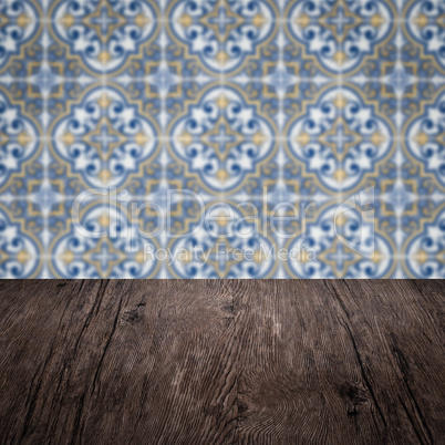 Wood table top and blur vintage ceramic tile pattern wall