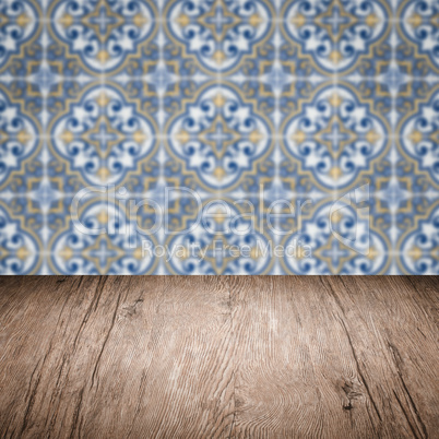 Wood table top and blur vintage ceramic tile pattern wall