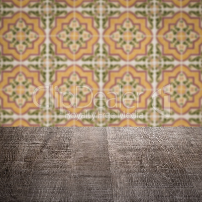 Wood table top and blur vintage ceramic tile pattern wall