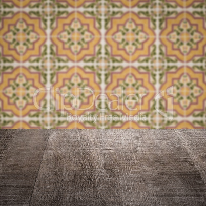 Wood table top and blur vintage ceramic tile pattern wall