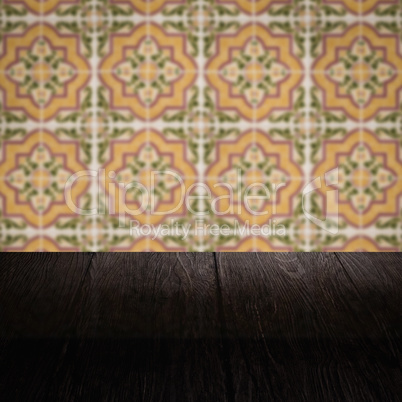 Wood table top and blur vintage ceramic tile pattern wall