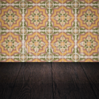 Wood table top and blur vintage ceramic tile pattern wall