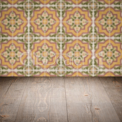 Wood table top and blur vintage ceramic tile pattern wall