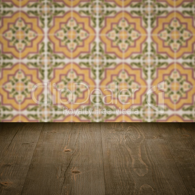 Wood table top and blur vintage ceramic tile pattern wall