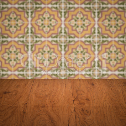 Wood table top and blur vintage ceramic tile pattern wall