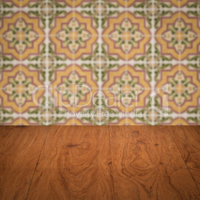 Wood table top and blur vintage ceramic tile pattern wall