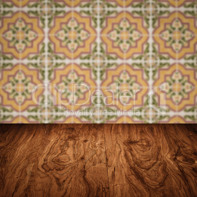 Wood table top and blur vintage ceramic tile pattern wall