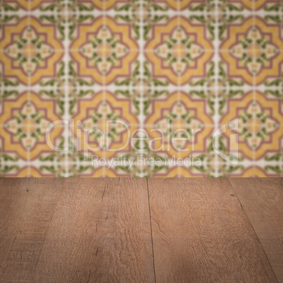 Wood table top and blur vintage ceramic tile pattern wall