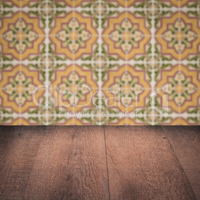 Wood table top and blur vintage ceramic tile pattern wall