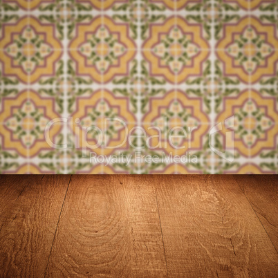 Wood table top and blur vintage ceramic tile pattern wall