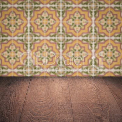 Wood table top and blur vintage ceramic tile pattern wall