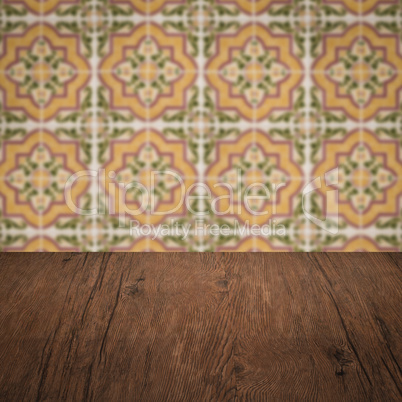 Wood table top and blur vintage ceramic tile pattern wall