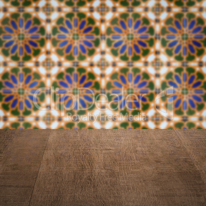 Wood table top and blur vintage ceramic tile pattern wall Wood table top and blur vintage ceramic tile pattern wall