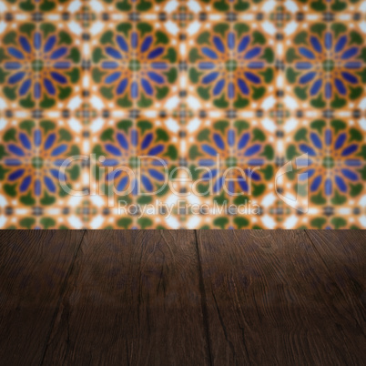 Wood table top and blur vintage ceramic tile pattern wall