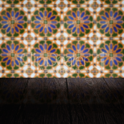 Wood table top and blur vintage ceramic tile pattern wall