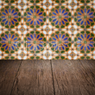 Wood table top and blur vintage ceramic tile pattern wall