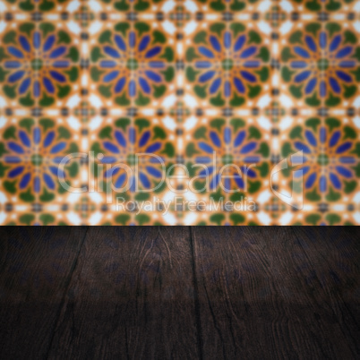 Wood table top and blur vintage ceramic tile pattern wall