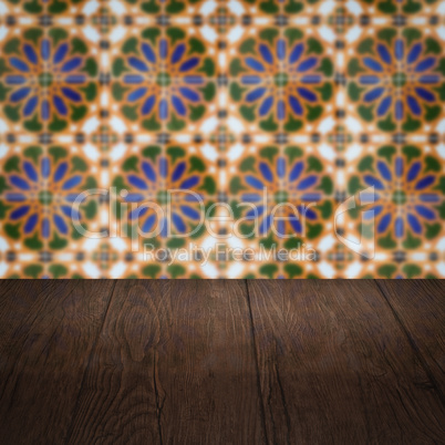 Wood table top and blur vintage ceramic tile pattern wall Wood table top and blur vintage ceramic tile pattern wall