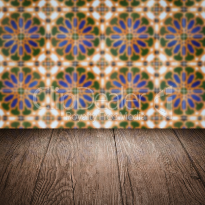 Wood table top and blur vintage ceramic tile pattern wall