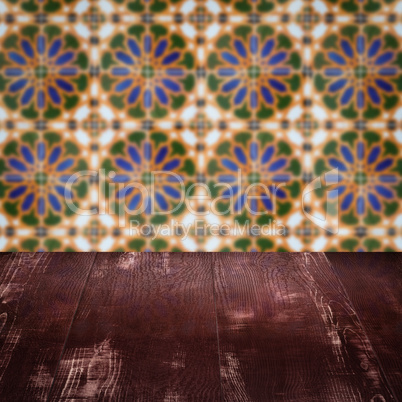 Wood table top and blur vintage ceramic tile pattern wall