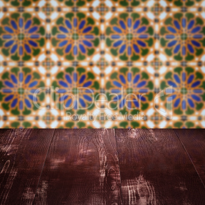 Wood table top and blur vintage ceramic tile pattern wall