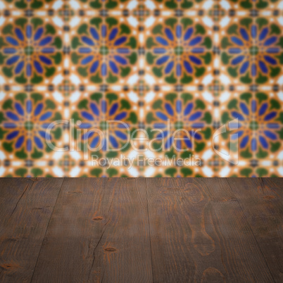 Wood table top and blur vintage ceramic tile pattern wall