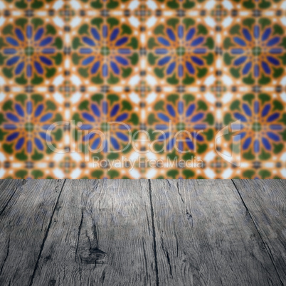 Wood table top and blur vintage ceramic tile pattern wall